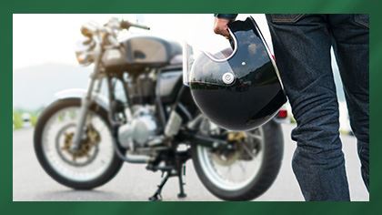 person holding helmet in front of motorcycle